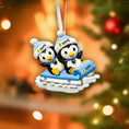 Load image into Gallery viewer, Personalized Christmas ornament with two penguins on a sled against a festive background.
