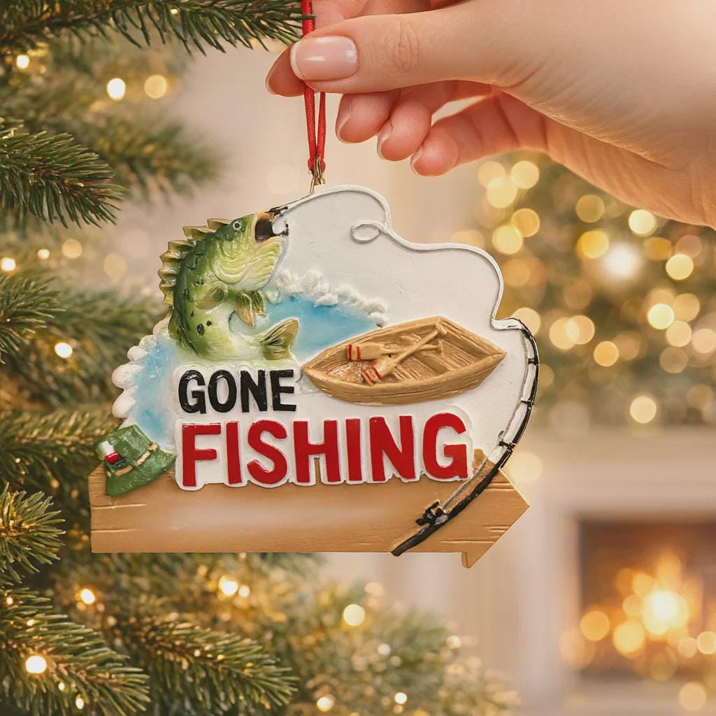 Fishing-themed Christmas ornament with a boat and fish on a tree.