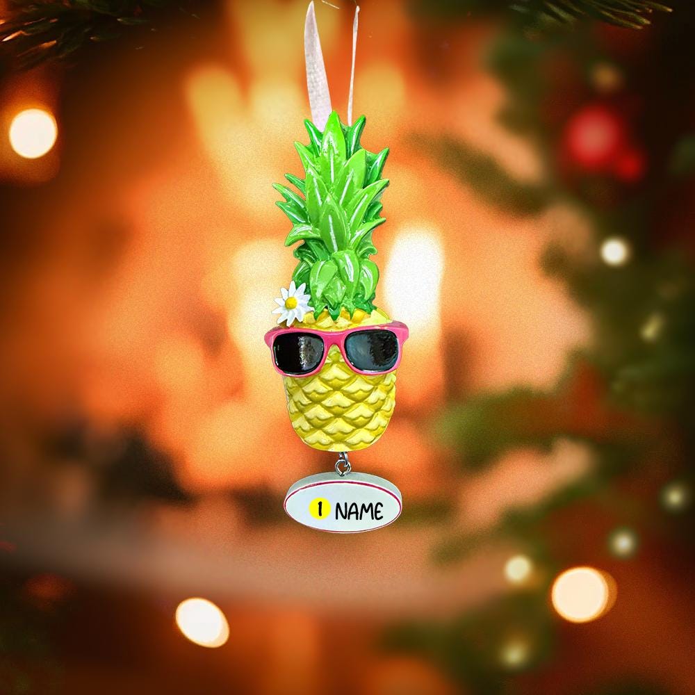Pineapple ornament with sunglasses on a Christmas tree with blurred lights in the background