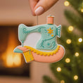 Load image into Gallery viewer, Personalized sewing machine ornament featuring a charming vintage style design with soft pastel colors and floral details. The ornament includes space for a name and year, making it a meaningful keepsake gift. Crafted from durable resin with a detailed 3D raised front and flat 2D back for smooth hanging. Includes free handwritten personalization. A perfect Christmas ornament gift for grandmothers sewing lovers quilters crafters and anyone who enjoys handmade traditions and creative hobbies.
