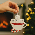 Load image into Gallery viewer, Decorative ornament shaped like a cup with marshmallows and a candy cane against a festive background.
