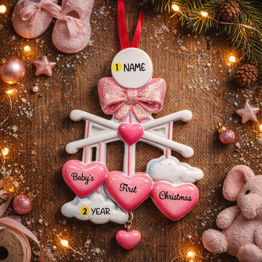 Personalized Baby Girl First Christmas Ornament featuring a dimensional 3D front design with pink glitter bow, heart charms, and hanging cloud detail. The baby’s name is added on the top circle and the year on the cloud, creating a meaningful keepsake. Soft pink tones, layered hearts reading Baby’s First Christmas, and festive holiday accents make it perfect for newborn girl gifts, baby shower presents, and treasured Christmas tree memories.