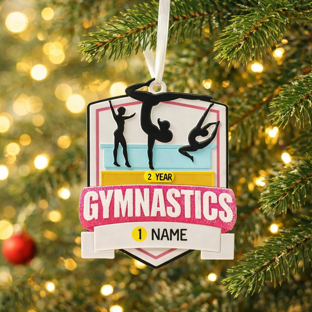 Personalized gymnastics Christmas ornament featuring elegant gymnast silhouette figures in motion, customizable name area on the front banner and customizable year area above the banner, glossy finish with raised 3D front details and flat 2D back, white hanging ribbon, displayed on a soft pink snowy holiday background with festive ornaments greenery and warm Christmas decor.
