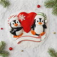 Load image into Gallery viewer, Decorative ornament with two penguins and a red heart on a snowy background
