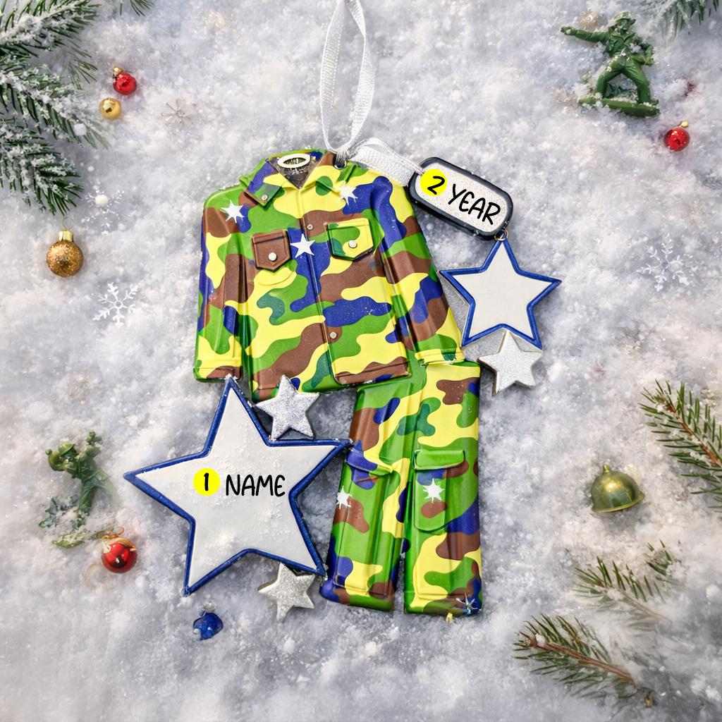A glossy resin Army soldier uniform ornament in green brown and blue camouflage colors features a military jacket and pants shape with raised buttons and pockets, white and blue star accents, light snow texture, a smooth painted cartoon style finish, and handwritten personalization showing a name and year on the attached tag, designed as a mostly 2D ornament with raised 3D details on the front only for Christmas tree decor.