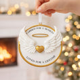 Load image into Gallery viewer, Decorative angel wing ornament with text against a festive background
