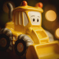 Load image into Gallery viewer, ornament bulldozer with a face on a dark background
