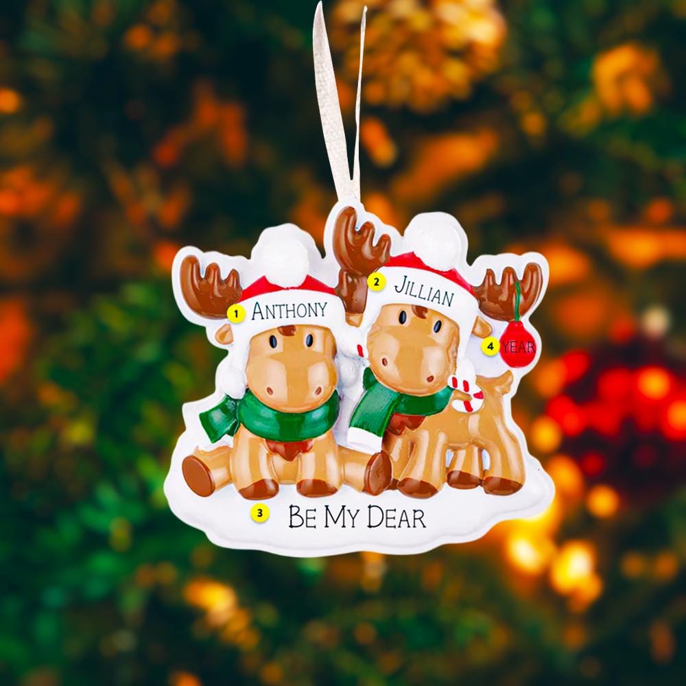 Close up view of a personalized reindeer couple ornament featuring two festive reindeer wearing Santa hats with customizable names. Designed to celebrate couples, families, siblings, or loved ones, this ornament highlights togetherness and holiday warmth. A charming Christmas keepsake perfect for tree decor, gift giving, and preserving shared holiday memories.
