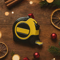 Load image into Gallery viewer, Black and yellow tape measure on a wooden surface with Christmas decorations

