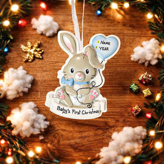 Decorative Christmas ornament with a rabbit holding a heart, surrounded by festive decorations on a wooden surface.