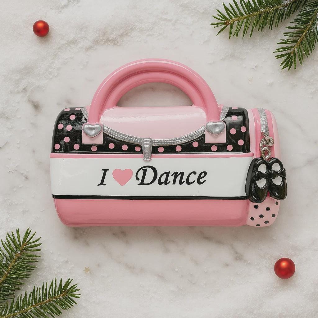 Pink and black polka dot handbag-shaped container with 'I ❤️ Dance' text on a marble surface with Christmas decorations.