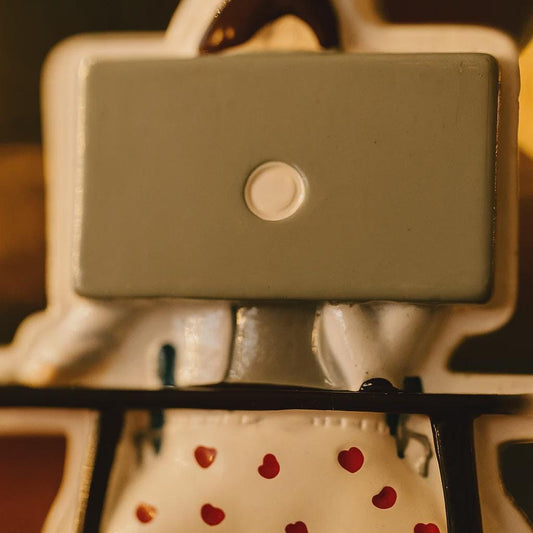 Close-up of a ornament object with a rectangular component and red heart patterns on a blurred background