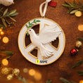 Load image into Gallery viewer, Decorative ornament with a dove and peace symbol on a wooden surface with festive decorations.
