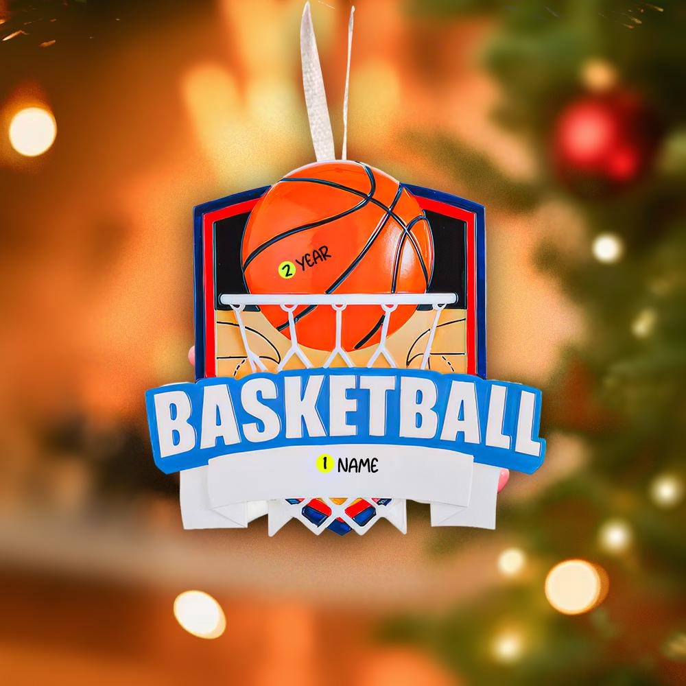 Personalized basketball Christmas ornament featuring an orange basketball and hoop design with customizable name area on the front banner and customizable year area on the basketball, glossy finish with raised 3D front details and flat 2D back, white hanging ribbon, displayed on a snowy basketball court themed holiday background with pine branches and festive decorations.