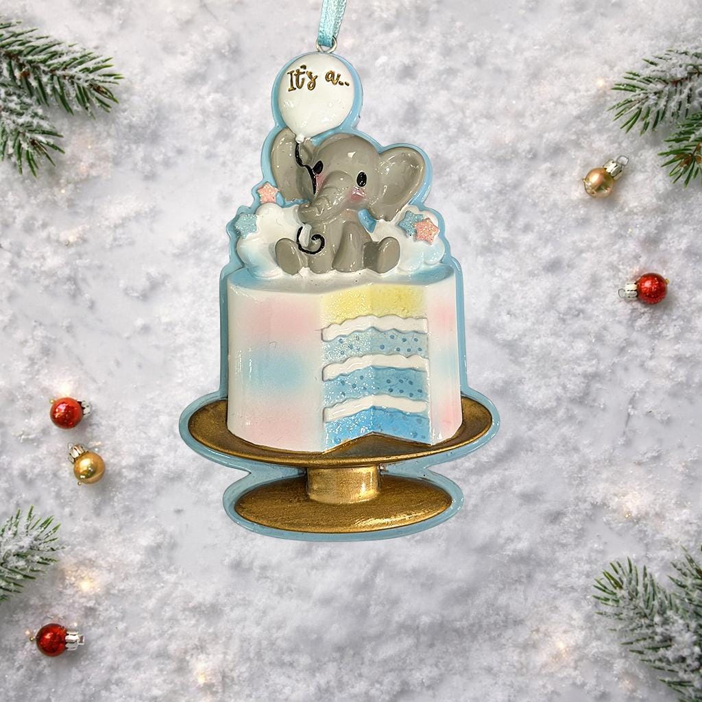 Decorative ornament with a baby elephant on a cake against a snowy background