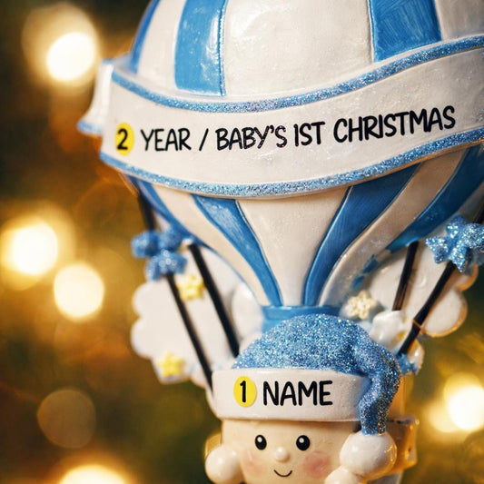 Personalized Baby Boy First Christmas Ornament designed as a charming 3D hot air balloon with a sweet baby in the basket below. The name is featured on the lower section and the year or Baby’s First Christmas message appears on the banner across the balloon. Soft blue and white tones, glitter accents, and raised dimensional details create a playful keepsake. Perfect for newborn boys, baby shower gifts, and celebrating a baby’s first holiday season.