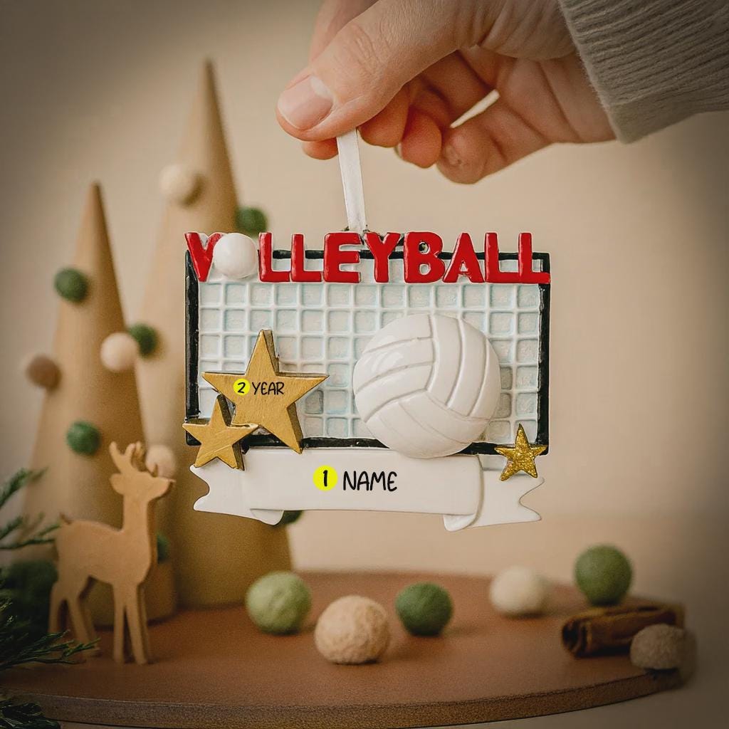 Volleyball-themed ornament with customizable text held by a hand against a decorative background.