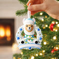 Load image into Gallery viewer, Personalized baby boy llama ornament featuring a cute smiling llama wearing a winter hat and surrounded by a festive wreath with colorful holiday lights. Soft blue and white tones create a cozy winter look. Handwritten personalization includes baby name and Baby’s First Christmas with year. Mostly 2D ornament with raised 3D details on the front only, lightweight and perfect for Christmas trees, nursery decor, and baby keepsakes.
