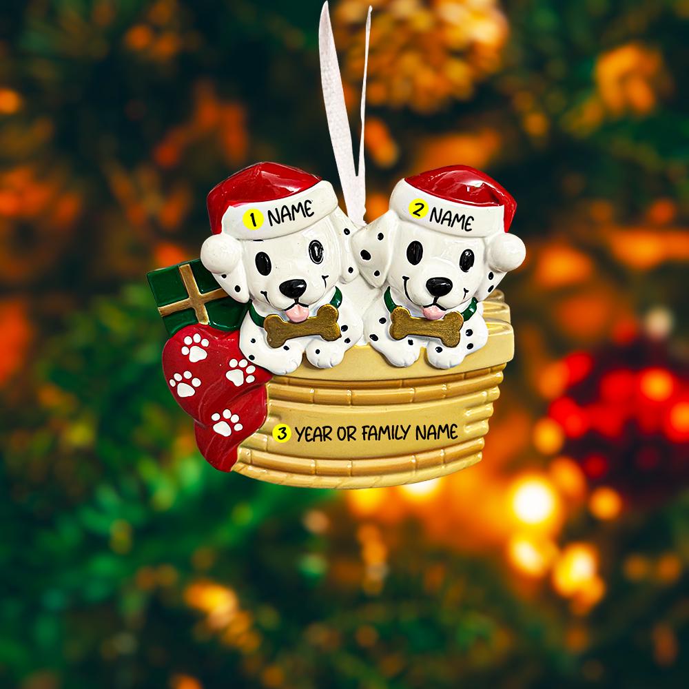 Personalized Christmas dog ornament featuring two adorable dalmatian puppies sitting together on a cozy basket, each wearing a Santa hat and holding a bone. Both puppies can be customized with names, while the front of the basket is personalized with a year or family name. Decorated with festive details like a stocking, gift box, and holiday accents, this ornament has a raised 3D front and smooth finish, making it perfect for dog lovers, couples, families, and Christmas tree decor.
