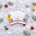 Load image into Gallery viewer, Personalized chef Christmas ornament featuring a white chef hat design with a wooden spoon and metal spatula details. Customized with a name and year on the front banner. Glossy resin finish with clean white and red accents creates a fun and professional cooking themed holiday look. Mostly 2D ornament with raised 3D details on the front only, lightweight and perfect for Christmas tree decor or kitchen themed gifts.
