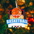 Load image into Gallery viewer, Personalized basketball Christmas ornament featuring an orange basketball and hoop design with customizable name area on the front banner and customizable year area on the basketball, glossy finish with raised 3D front details and flat 2D back, white hanging ribbon, displayed on a snowy basketball court themed holiday background with pine branches and festive decorations.
