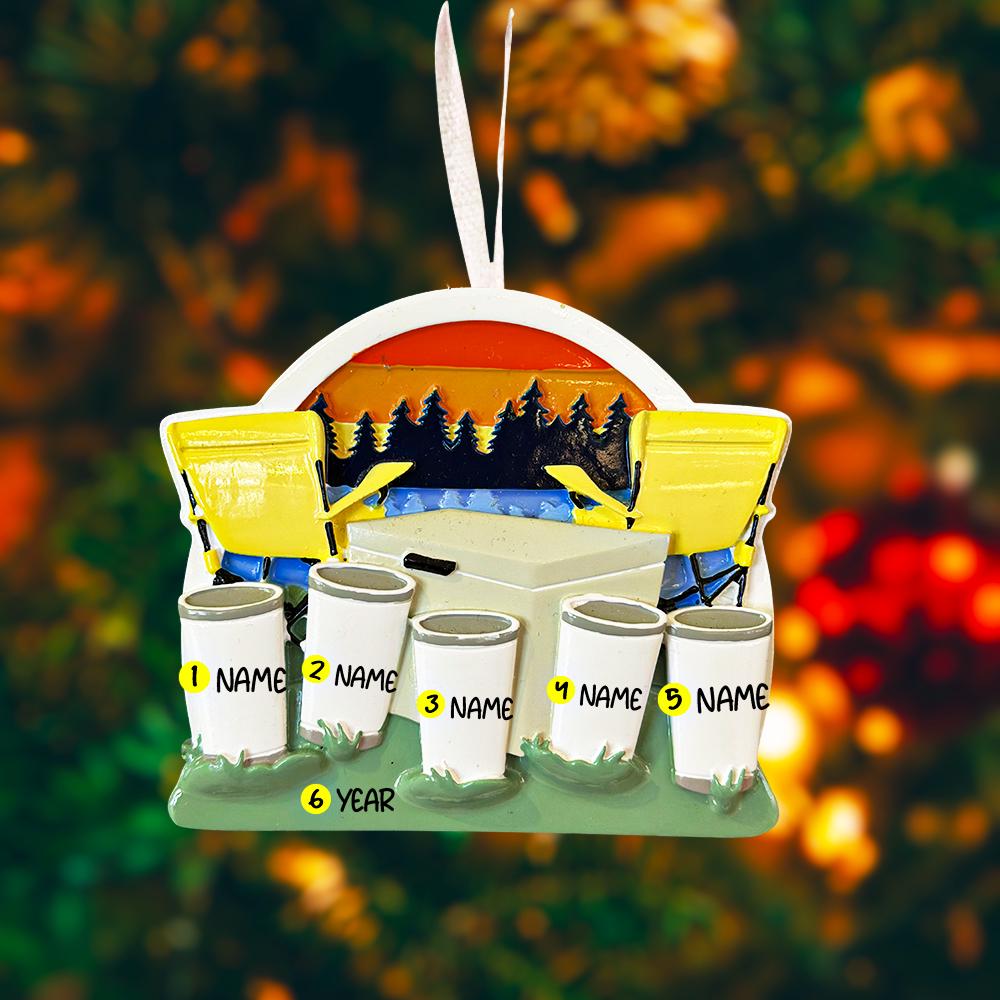 Decorative ski lift ornament with cups labeled 'NAME' against a blurred natural background