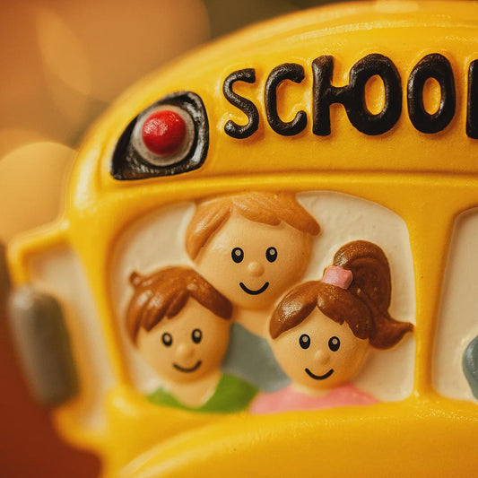 Toy school bus with children's faces on a blurred background