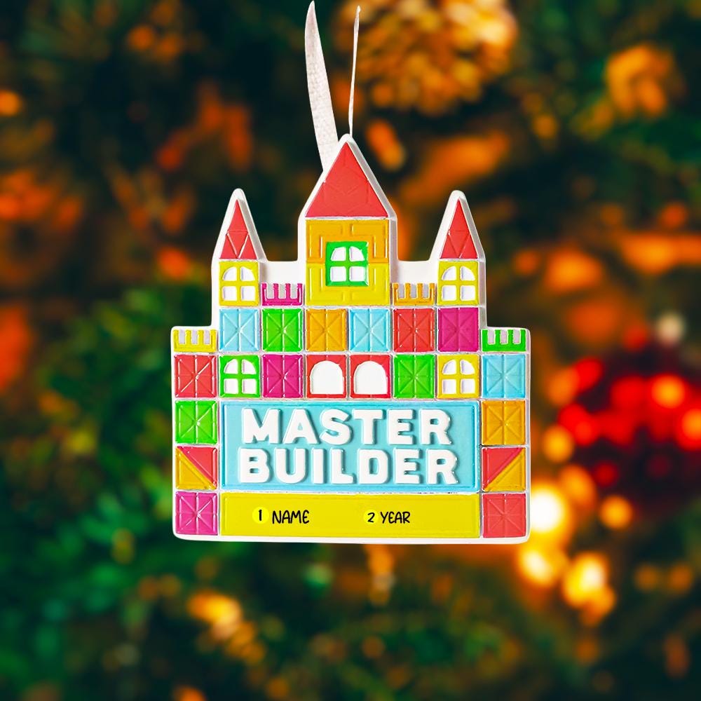 Colorful toy block castle ornament with 'Master Builder' text against a blurred festive background.