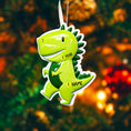 Load image into Gallery viewer, Personalized dinosaur Christmas ornament with a raised 3D front featuring a cute green dinosaur design and glossy detailed texture. The ornament has a flat 2D back for easy hanging and durability. Bright green color, playful smile, and sculpted spikes create a fun and eye catching look. Hand personalized with name and year. Perfect kids Christmas ornament, dinosaur themed holiday decor, and personalized keepsake gift.
