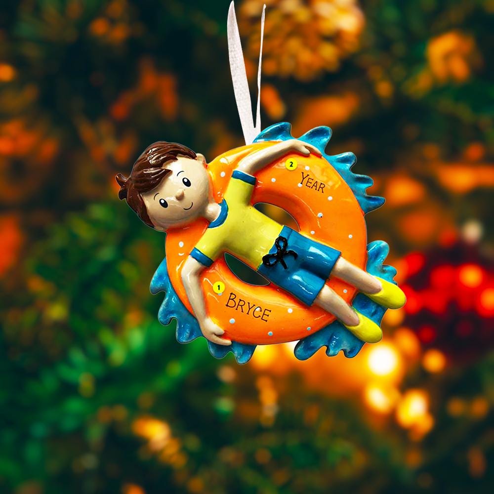 Decorative ornament of a child on an inner tube with 'Bryce' written on it, against a blurred natural background.