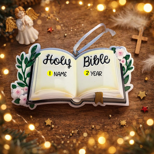 Personalized Holy Bible Christmas Ornament featuring an open scripture design with elegant “Holy Bible” lettering across the pages. The left page is customized with a name and the right page displays the year, creating a meaningful faith based keepsake. Surrounded by soft greenery and delicate flowers, this religious ornament is perfect for baptisms, baby dedications, first communions, or celebrating a Christ centered Christmas. A thoughtful spiritual gift for families who cherish their faith.
