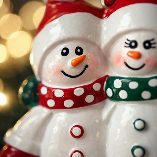 Two snowman ornaments with colorful scarves against a blurred festive background