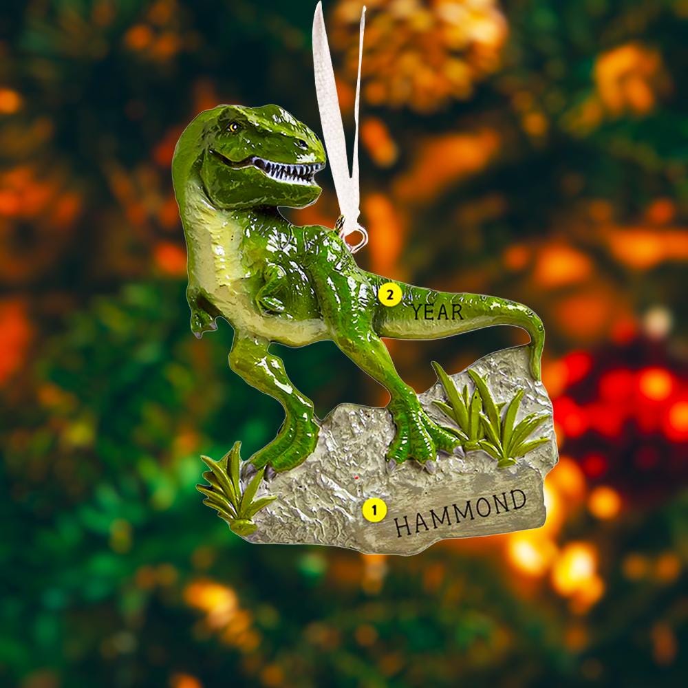 Realistic dinosaur themed Christmas ornament featuring a detailed T-Rex design with vibrant green tones and a playful yet bold appearance. Styled in a warm holiday setting, this ornament is designed to be personalized and makes a fun keepsake for kids who love dinosaurs and adventure themed decorations