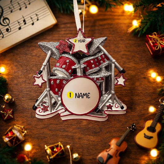 Personalized drum set ornament featuring a detailed red and silver drum kit with cymbals and star accents. Customizable with one name and a year. Crafted from resin with a glossy finish, featuring 3D raised front drum elements and a flat 2D back for balanced hanging. Finished with a satin ribbon. Designed for drummers musicians band members and music themed Christmas tree decor.