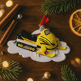 Load image into Gallery viewer, Christmas ornament of a snowmobile on a wooden surface with festive decorations
