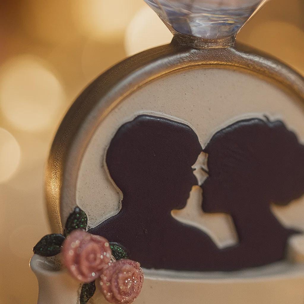 Decorative item with a silhouette of a couple and flowers on a blurred background
