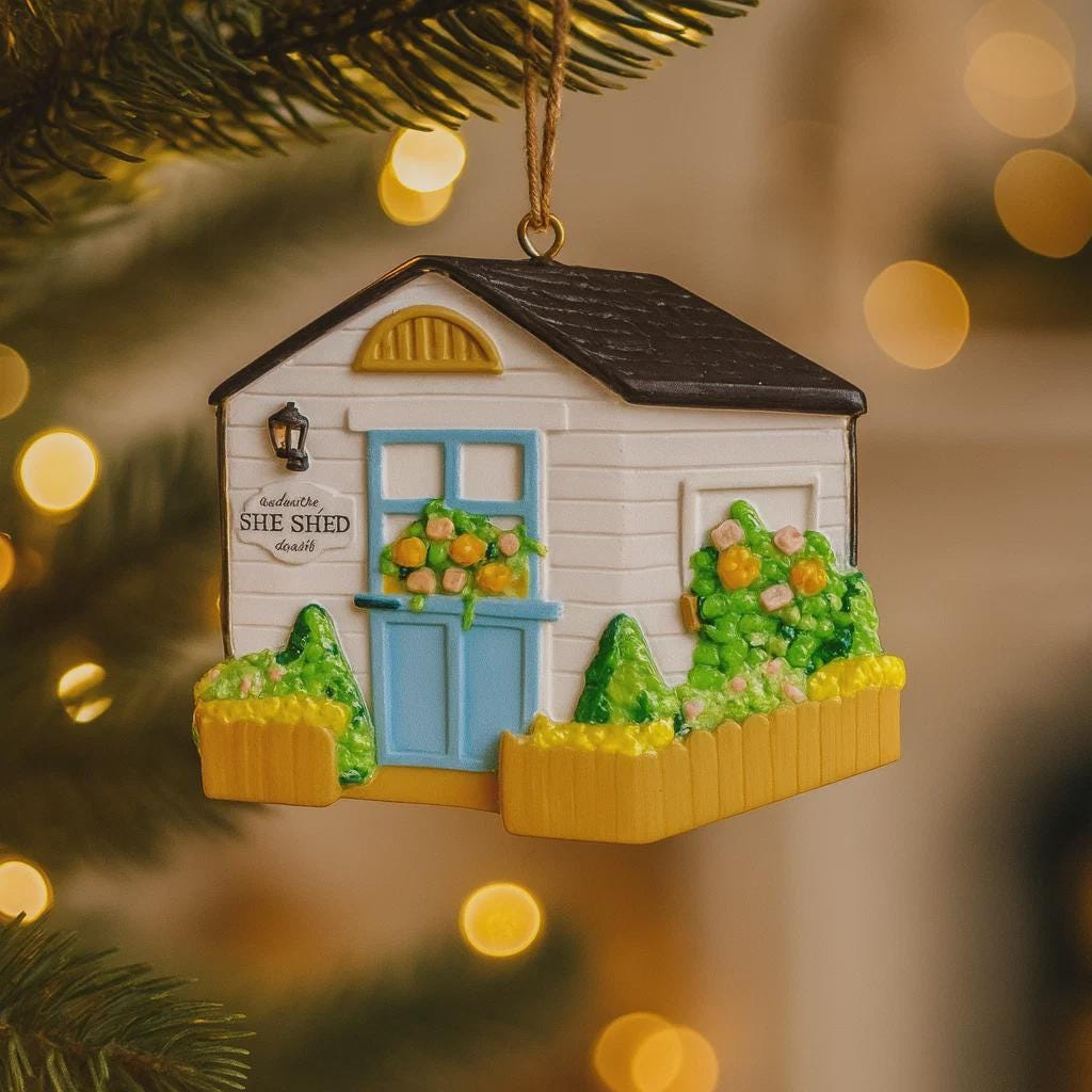 Decorative ornament of a small house with 'She Shed' sign on a Christmas tree.