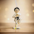 Load image into Gallery viewer, Decorative ornament of a martial artist with customizable name and year on a wooden surface.
