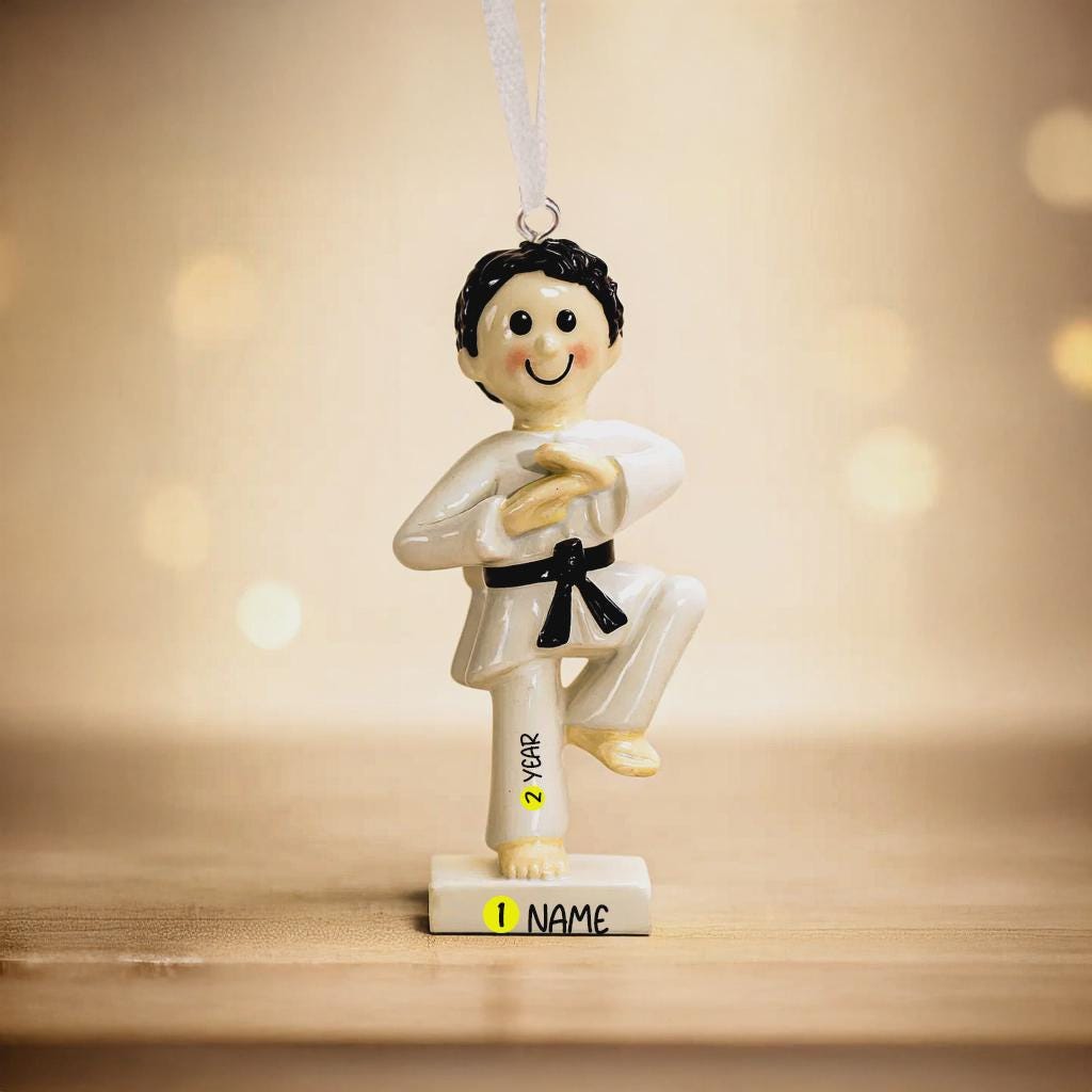 Decorative ornament of a martial artist with customizable name and year on a wooden surface.