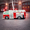 Load image into Gallery viewer, Toy fire truck ornament with a blurred fire station background
