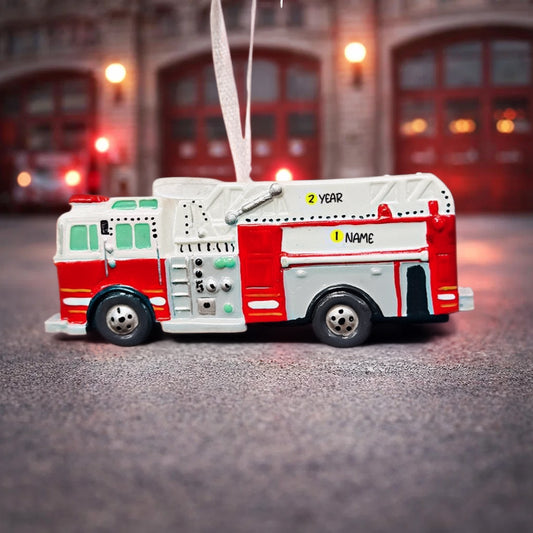 Toy fire truck ornament with a blurred fire station background