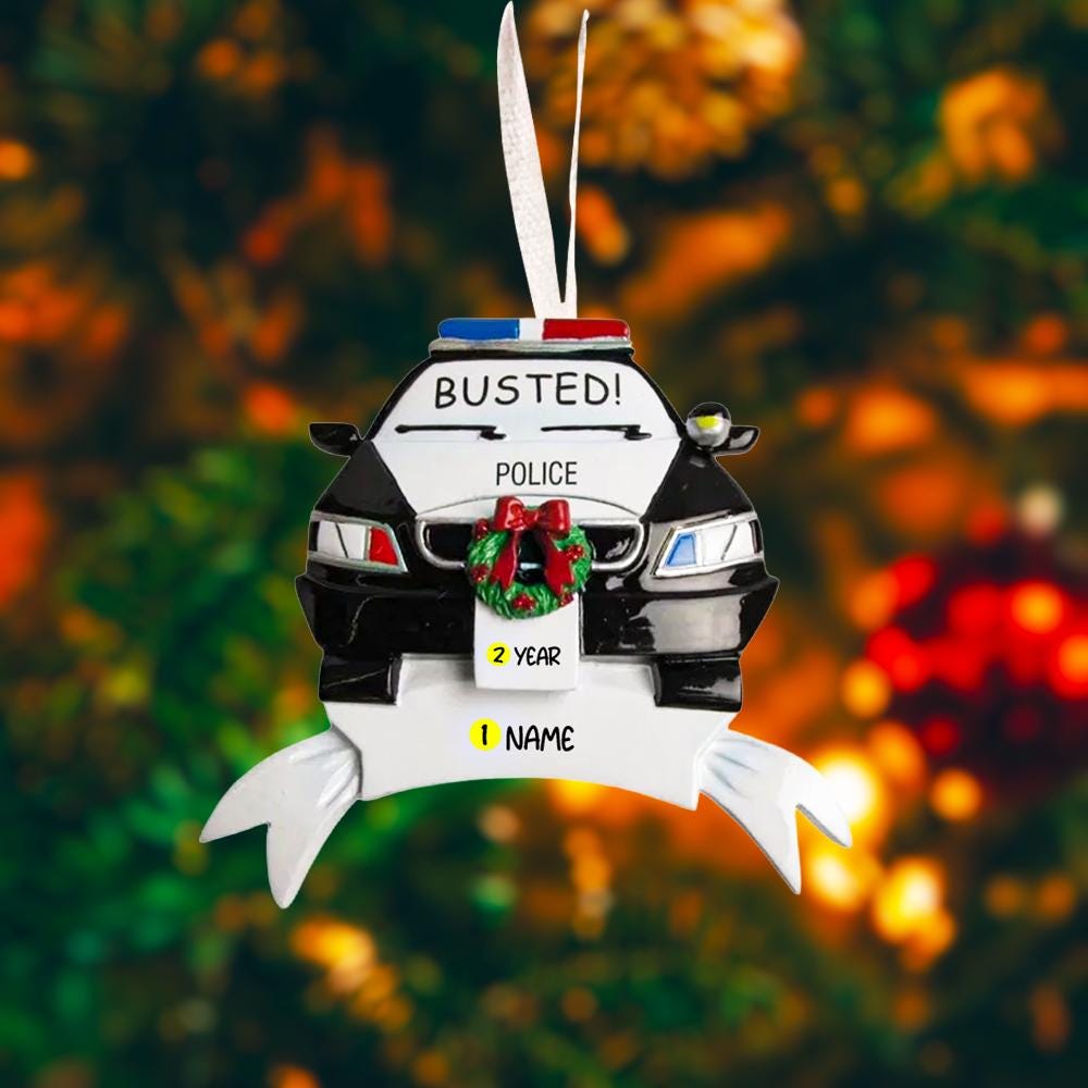 Personalized police car Christmas ornament featuring a black and white cop car design with BUSTED text, police lights and festive wreath detail. Customized with a name and year on the front banner. Glossy resin finish with bold black and white colors creates a fun and playful holiday look. Mostly 2D ornament with raised 3D details on the front only, lightweight and perfect for Christmas tree decor and police themed gifts.