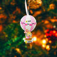 Load image into Gallery viewer, A personalized baby girl ornament featuring a cute bunny riding a pastel pink hot air balloon. Soft pink and white tones with delicate bow details create a sweet and cozy look. Handwritten personalization includes baby name and year. Mostly 2D ornament with raised 3D details on the front only, lightweight and easy to hang, perfect for baby first Christmas, nursery decor, and toddler keepsakes.
