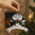 Load image into Gallery viewer, Personalized police car Christmas ornament featuring a black and white cop car design with BUSTED text, police lights and festive wreath detail. Customized with a name and year on the front banner. Glossy resin finish with bold black and white colors creates a fun and playful holiday look. Mostly 2D ornament with raised 3D details on the front only, lightweight and perfect for Christmas tree decor and police themed gifts.
