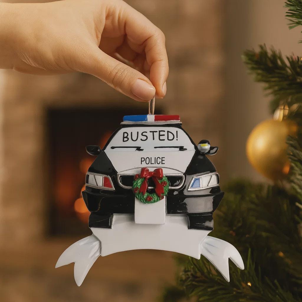 Personalized police car Christmas ornament featuring a black and white cop car design with BUSTED text, police lights and festive wreath detail. Customized with a name and year on the front banner. Glossy resin finish with bold black and white colors creates a fun and playful holiday look. Mostly 2D ornament with raised 3D details on the front only, lightweight and perfect for Christmas tree decor and police themed gifts.