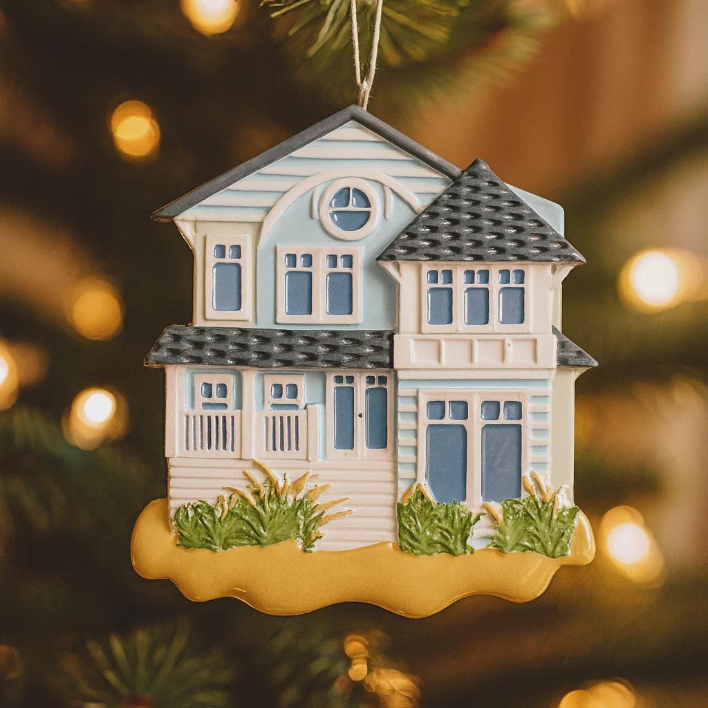 Decorative house ornament on a blurred Christmas tree background
