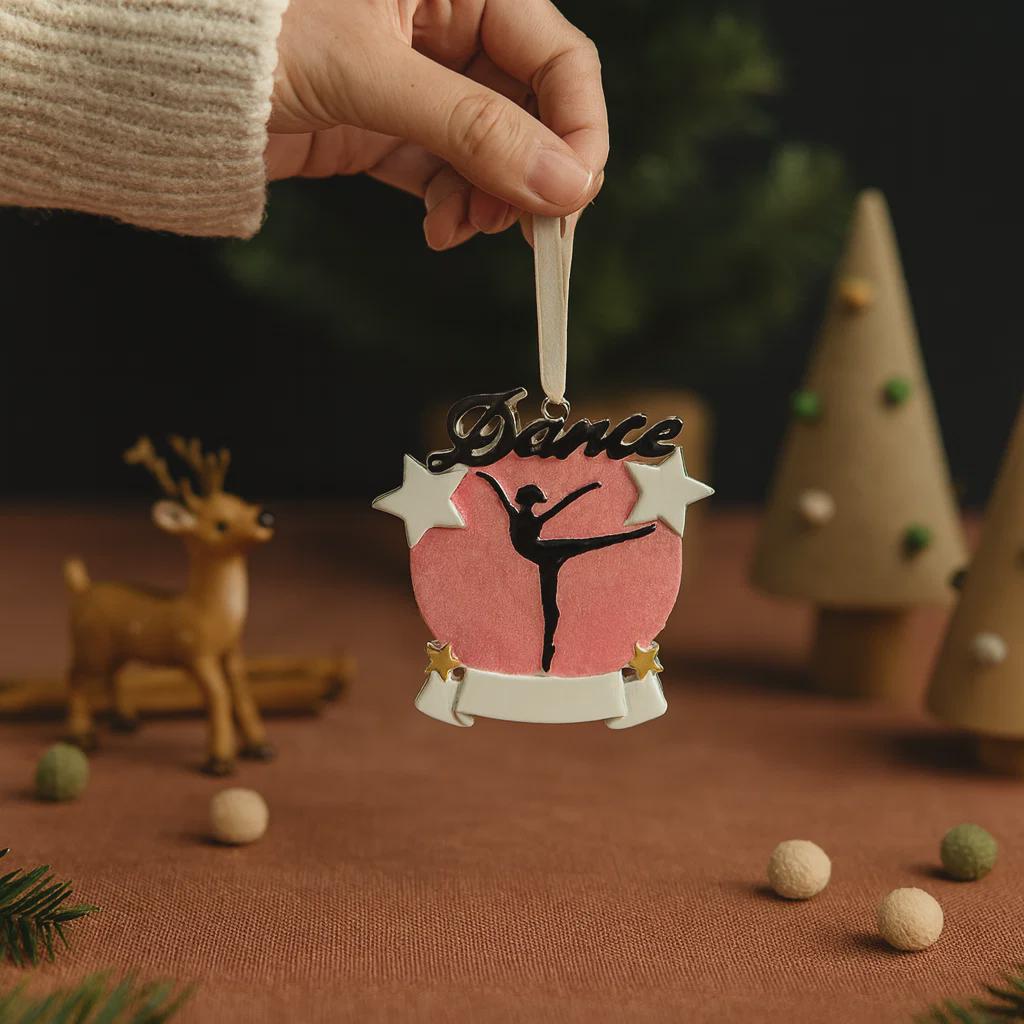 Decorative ornament with a dancer and 'Dance' text, held by a hand against a festive background.