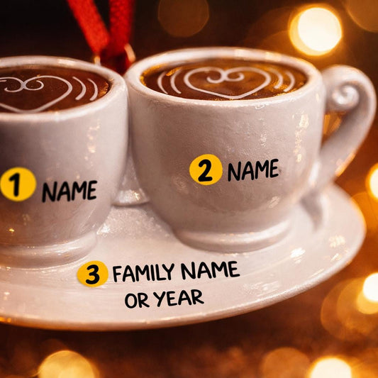 Two white coffee cups with latte art on a saucer against a blurred lights background