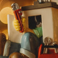Load image into Gallery viewer, Toy figure holding a wrench with a blurred background
