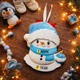 Load image into Gallery viewer, Personalized Snowman Baby Christmas Ornament featuring a cheerful snowman with blue glitter hat and scarf, holding a sparkling ornament. This design has a raised 3D front with textured details, dimensional elements, and vibrant winter colors. The child’s name is placed on the scarf and the year is added below. A perfect keepsake for baby’s first Christmas, newborn gift, winter holiday decoration, and meaningful family tree memory ornament.
